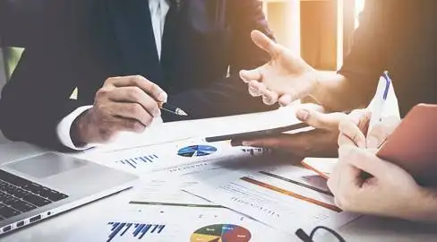 A group of business people sitting at a desk.